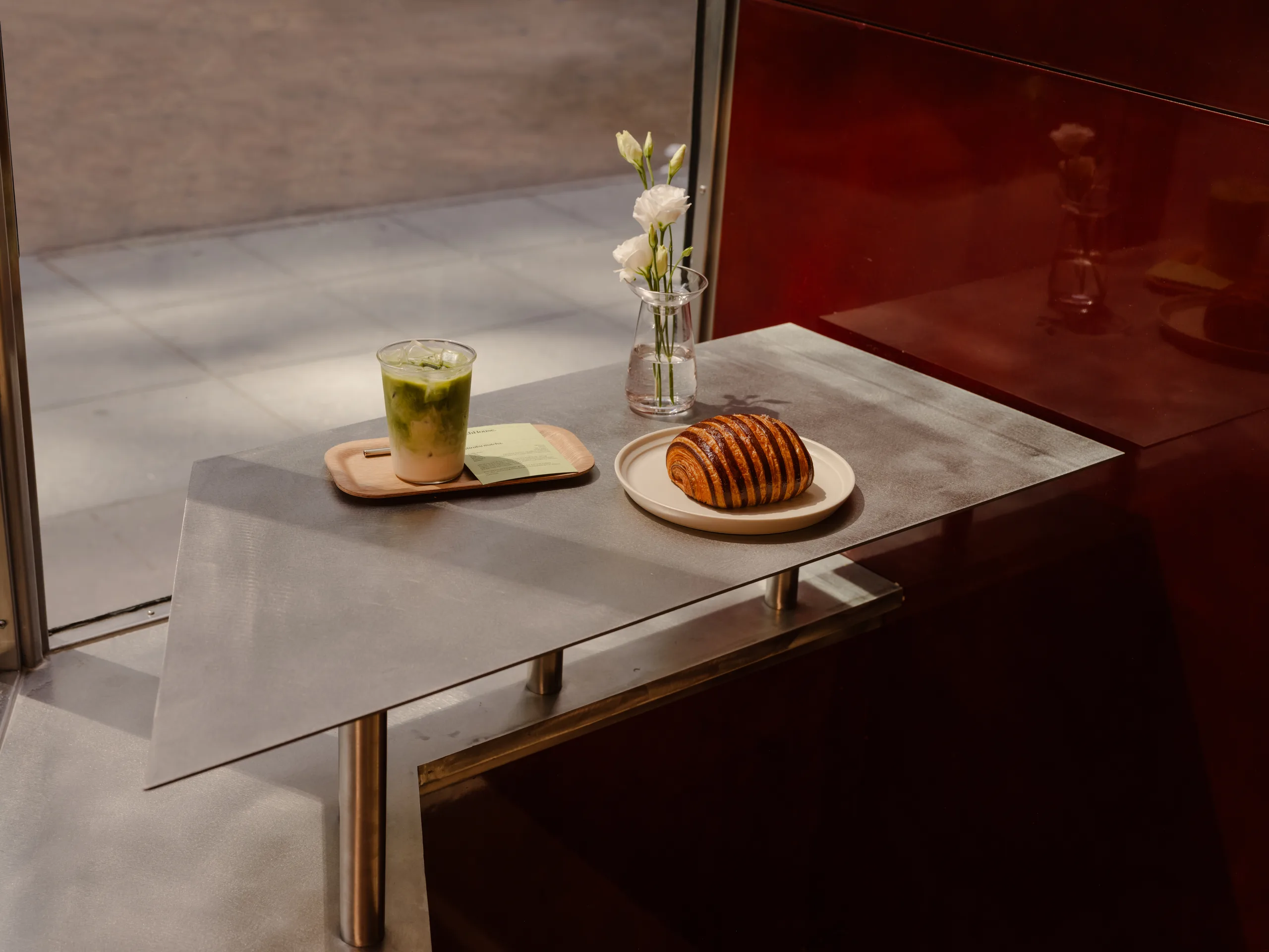 WatchHouse Chrysler table detail with brushed metal and lacquered wall finish