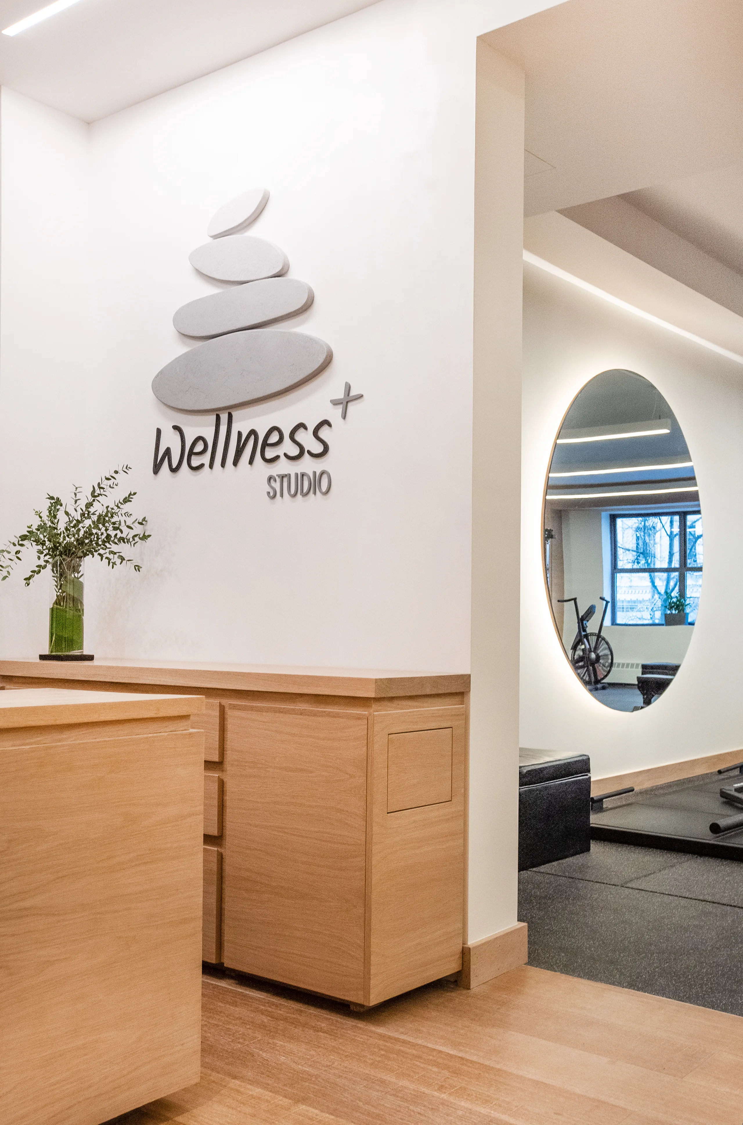 DRAX Wellness Center reception detail with wood cabinetry and oval mirror